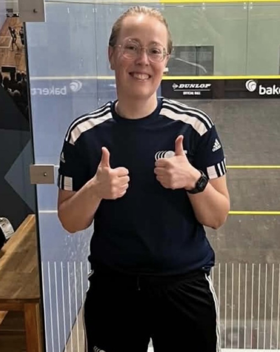 Billede af bestyrelsesmedlem i OSC, Ditte Bonde Mikkelsen, i sportstøj foran en squashbane.