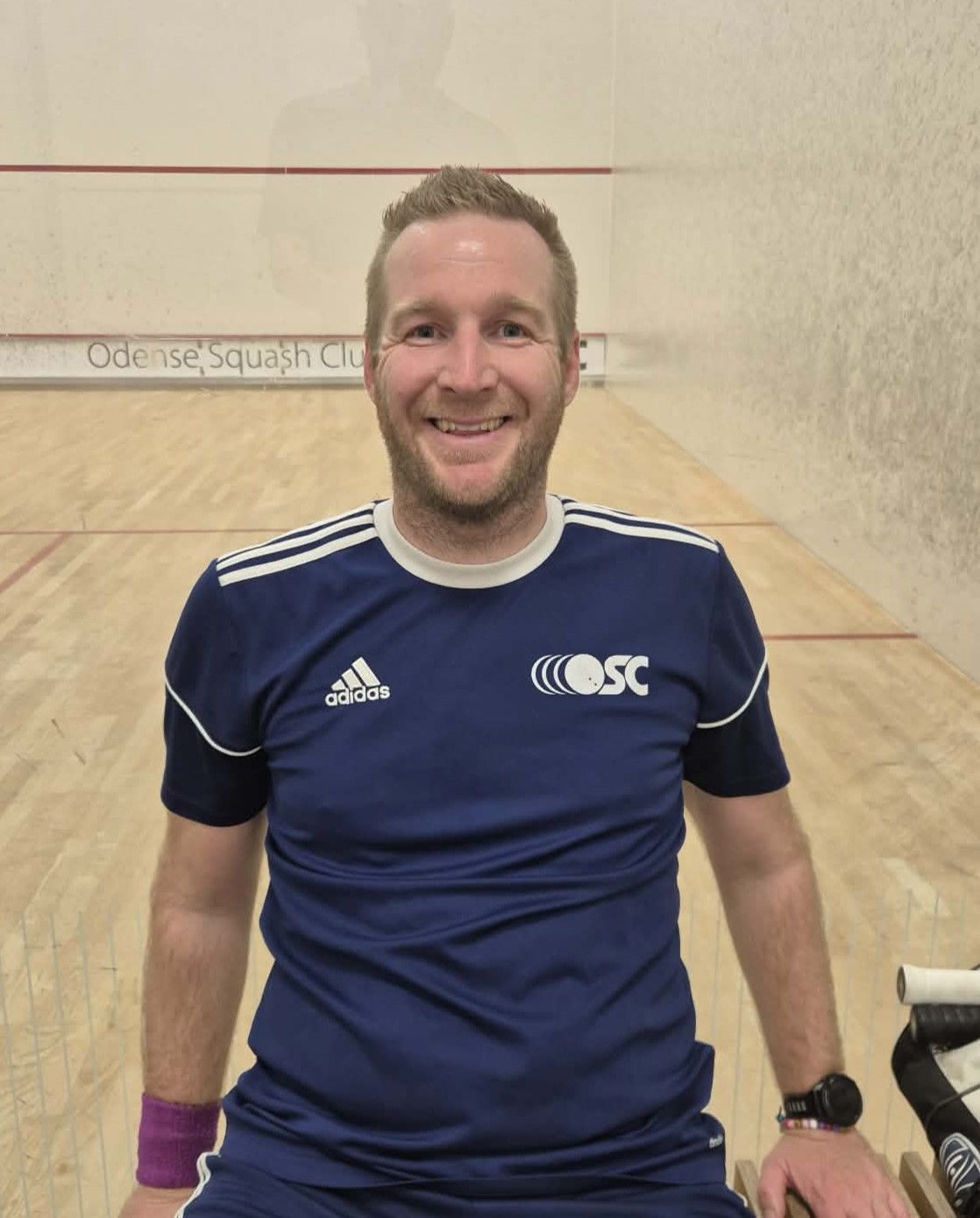 Billede af formand for OSC, Thomas Korsgaard Søgaard, i sportstøj foran en squashbane.